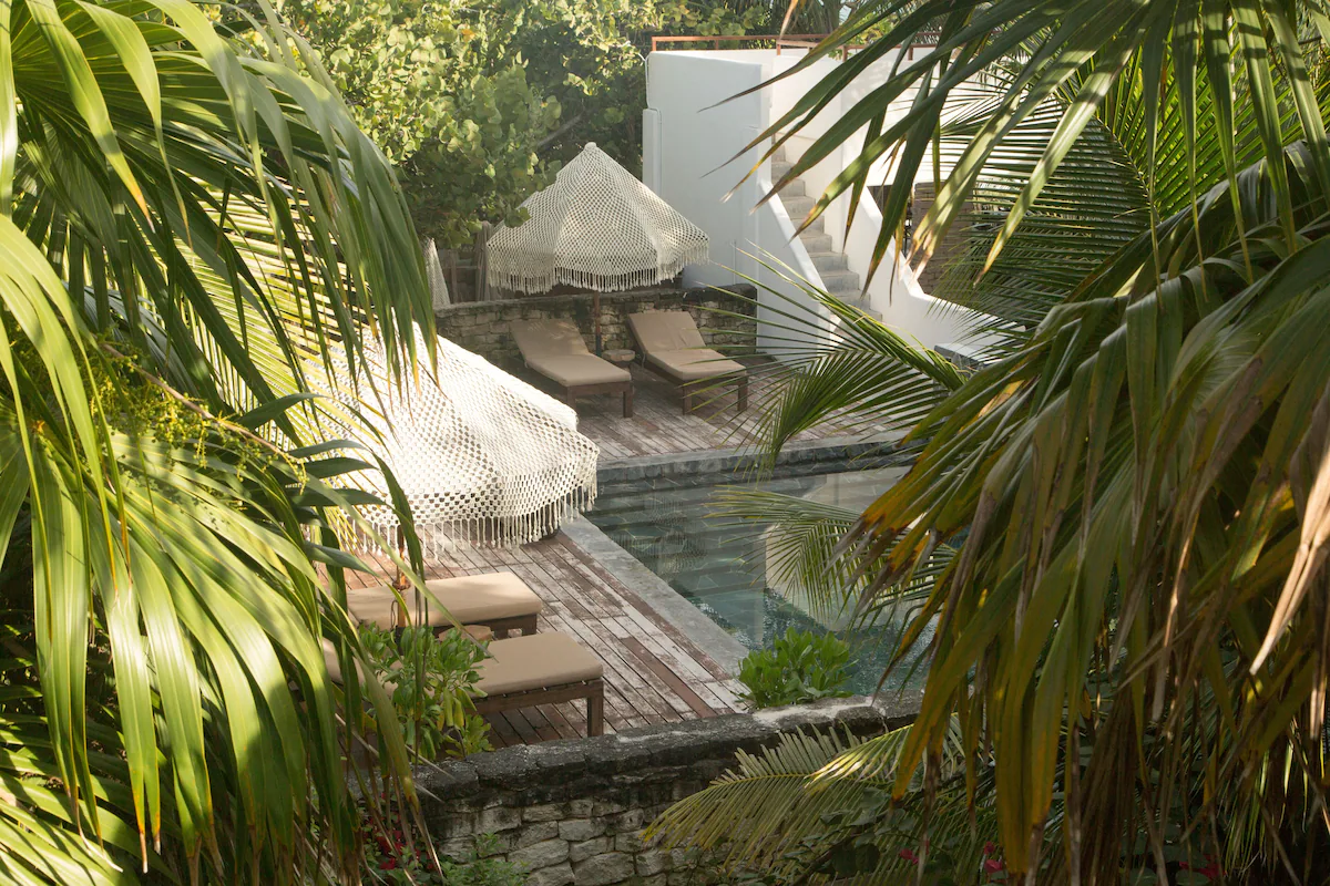 Pool loungers with white crochet umbrellas at Chiringuito Tulum 