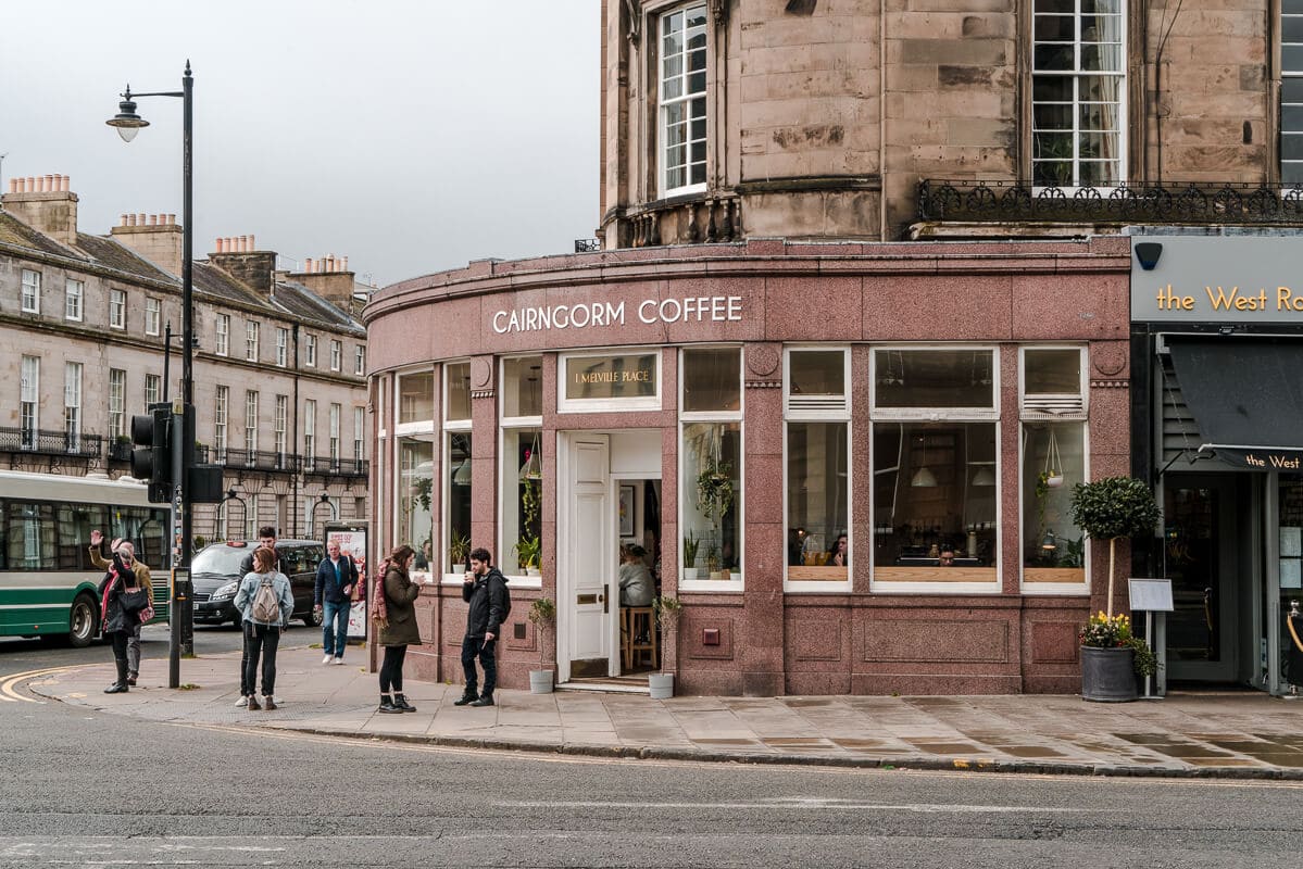 People walking at a corner of a street in front of the Cairngorm Coffee