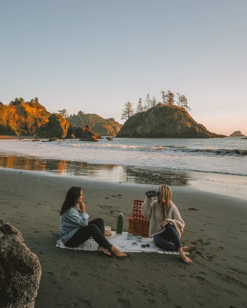 girls on the beach Two girls sitting on the beach on a picnic blanket