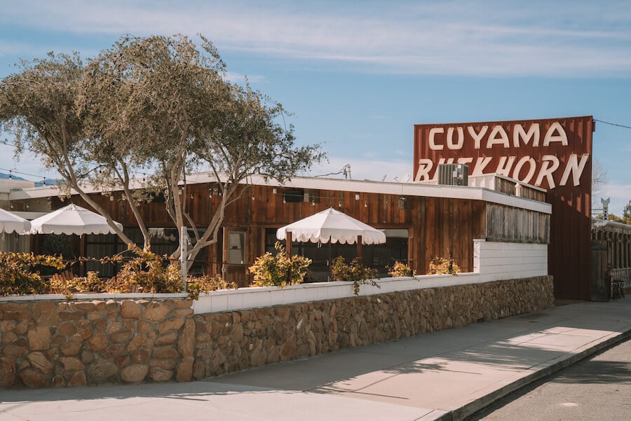 Exterior of Cuyama Buckhorn with retro sign and porch umbrellas