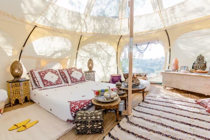 Interior of Moroccan style glamping tent with ornate pillows and rugs