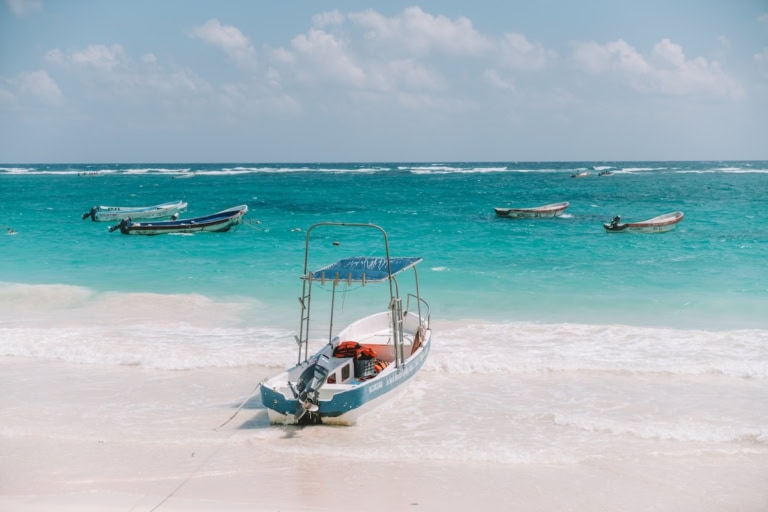 Picture of boats floating against turquoise water in Tulum
