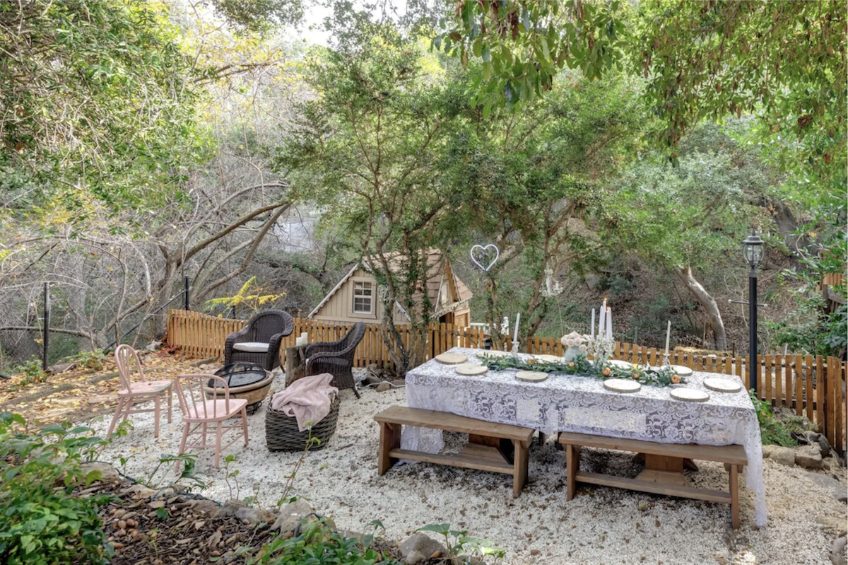 Dreamy backyard setup with table and chairs that look out of a fairytale