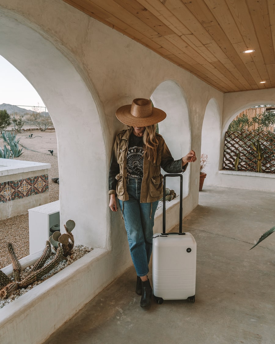 Michelle Halpern holding the Monos carry-on case in stellar white