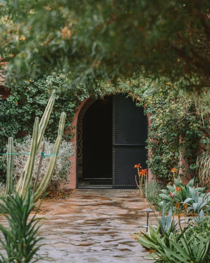 Curved doorway surrounded by lush greenery