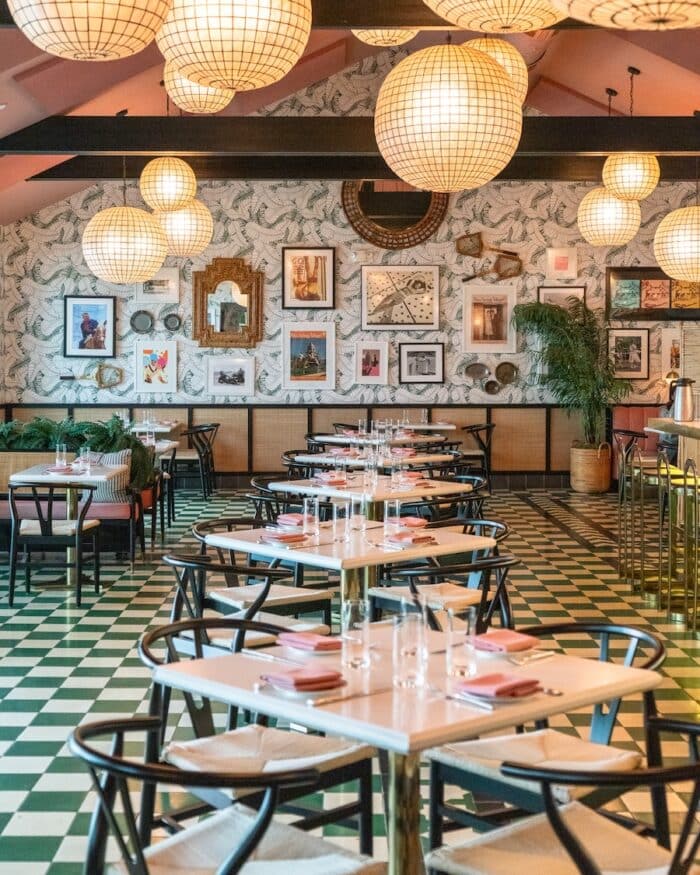 Funky and colorful green and pink interior with wall covered in prints and wallpaper