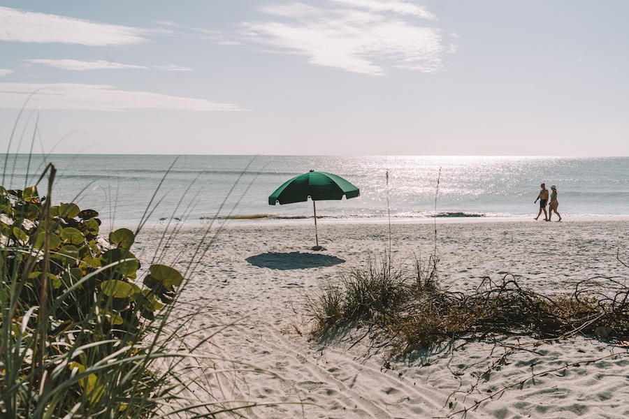 Daytime beach scene and green umbrella on Sanibel Island