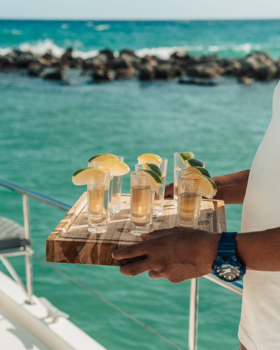 Bartender offering tequila shots on a yacht cruise on a trip to Tulum