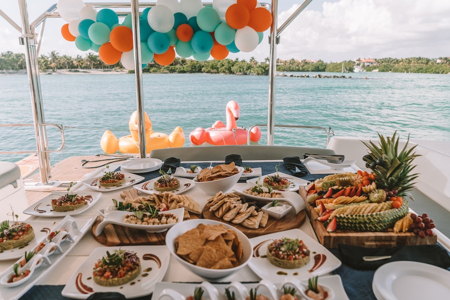 Food spread and pool floaties on a luxury yacht cruise in Tulum