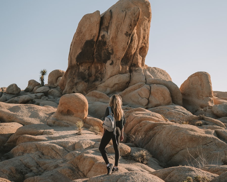 Michelle Halpern posing in front of boulders for things to do in Joshua Tree blog