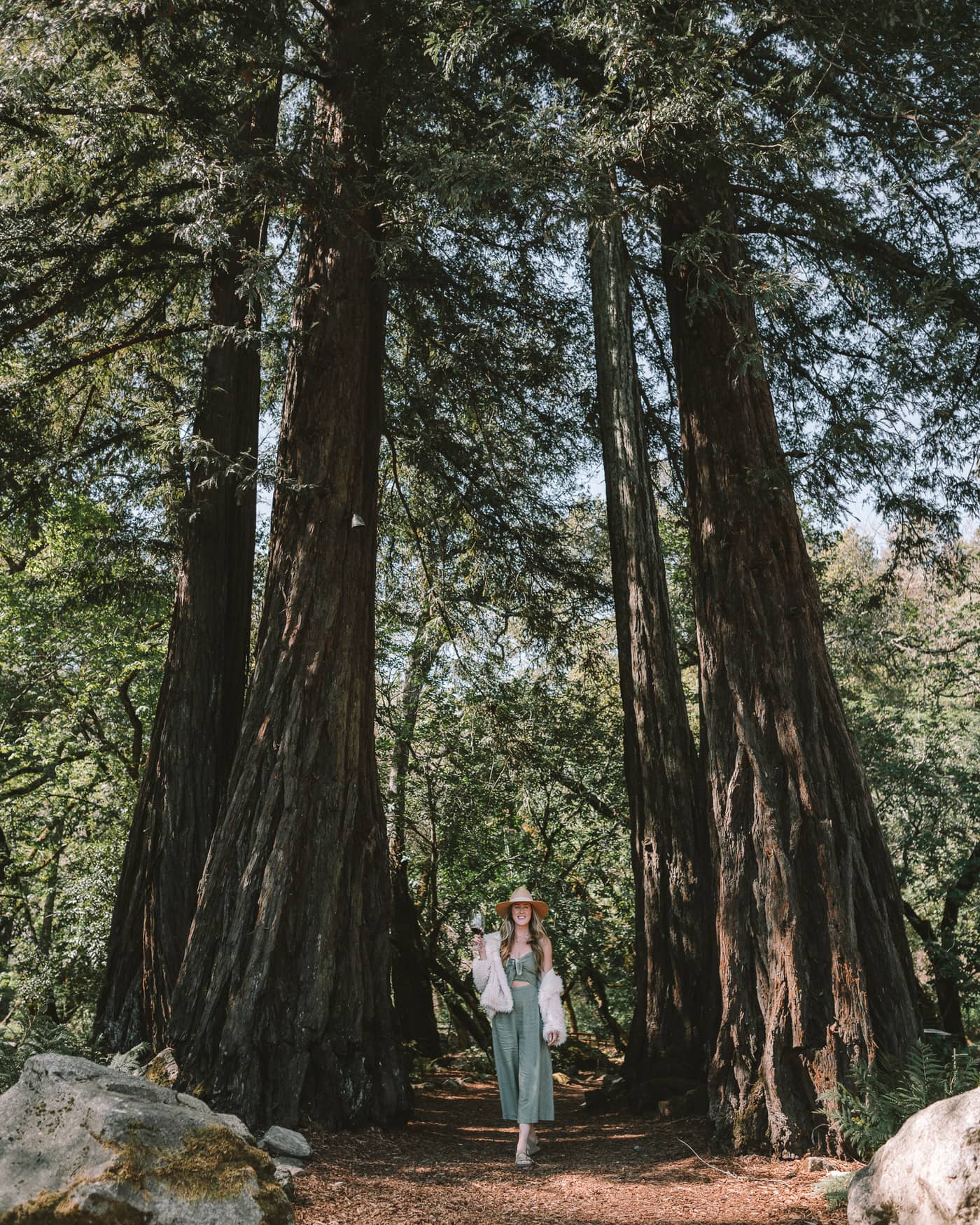 Michelle Halpern drinking wine under the Redwoods trees at AXR winery