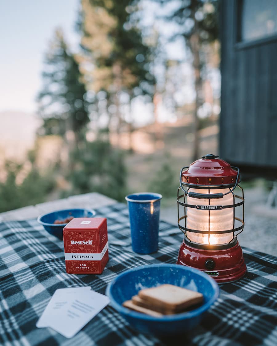 Best Self Intimacy card deck, appetizers and a lantern on the table outside Getaway House