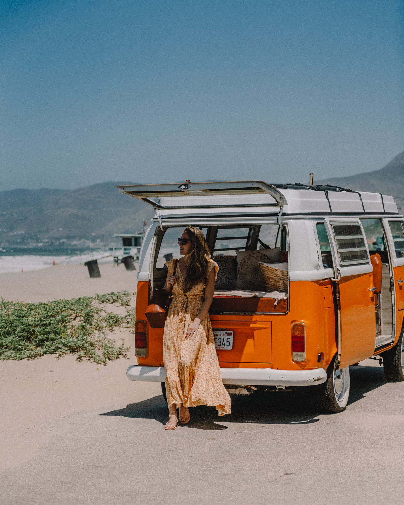 Michelle Halpern in Malibu, California with an orange VW bus at the beach