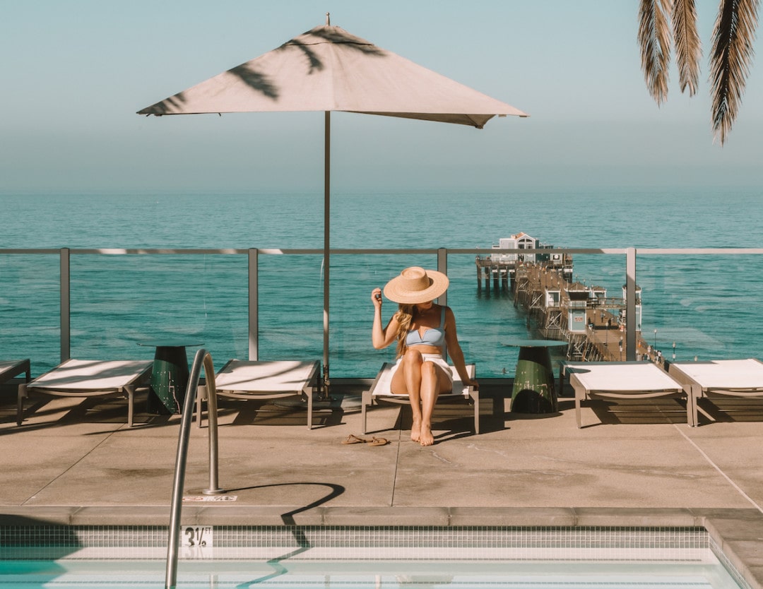 Michelle Halpern sitting on pool lounge chair on pool deck overlooking ocean