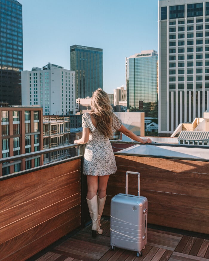Michelle Halpern on rooftop in New Orleans with Monos luggage - how to pack a suitcase to maximize space