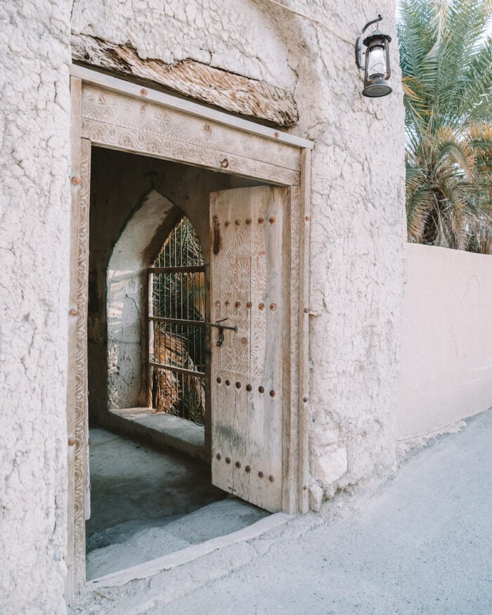 Beautiful ornate doorway on an alleyway in Nizwa that you'll find on this Oman road trip itinerary 