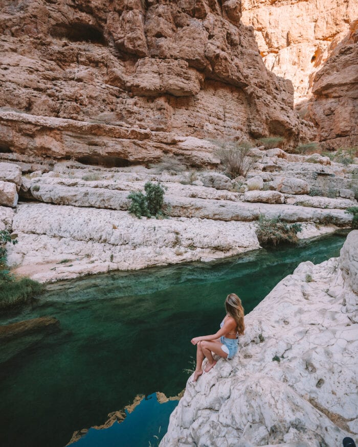 Michelle Halpern sitting on the rocks in Wadi Shab in Oman