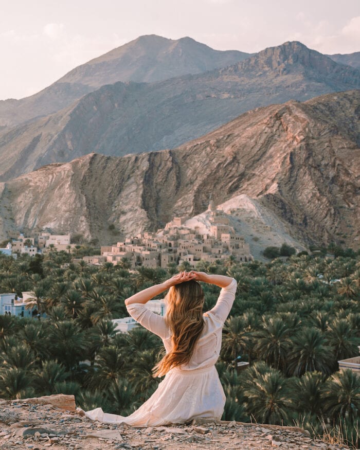 Michelle Halpern sitting at the viewpoint overlooking the Al Mouz Ruins -Oman road trip itinerary
