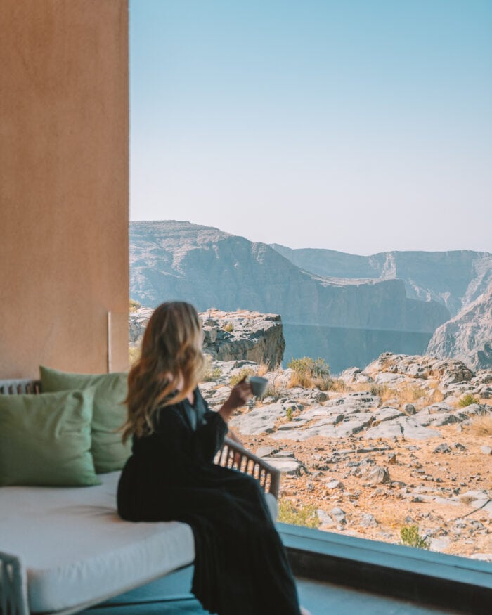 Michelle Halpern holding a cup of coffee overlooking the mountains outside her hotel room