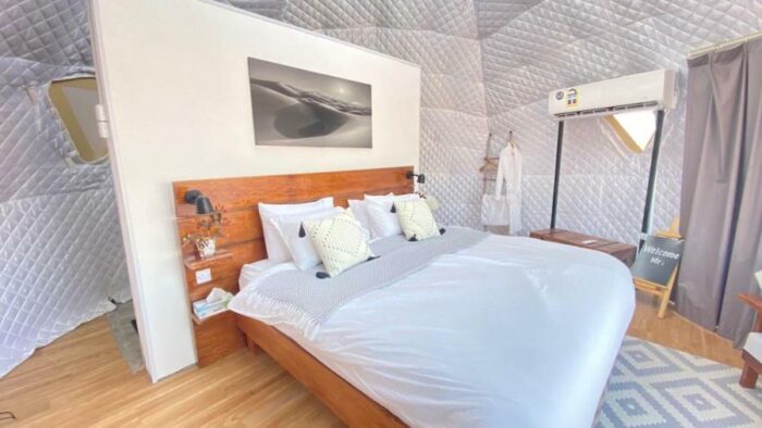 Interior of geodesic dome in the Oman desert with white linens, spacious