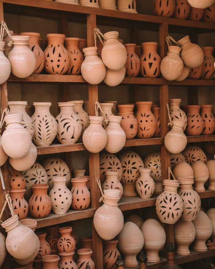 Neutral toned pottery stacked on shelves inside the souk