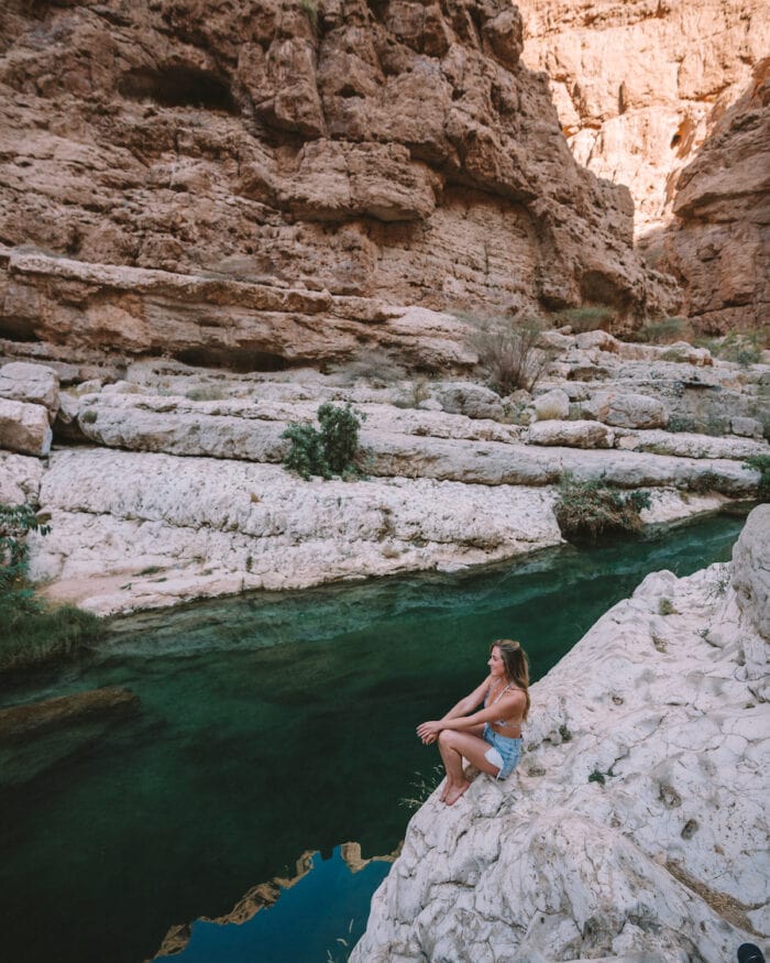 Michelle Halpern sitting at the edge of Wadi Shab swimming hole in Oman
