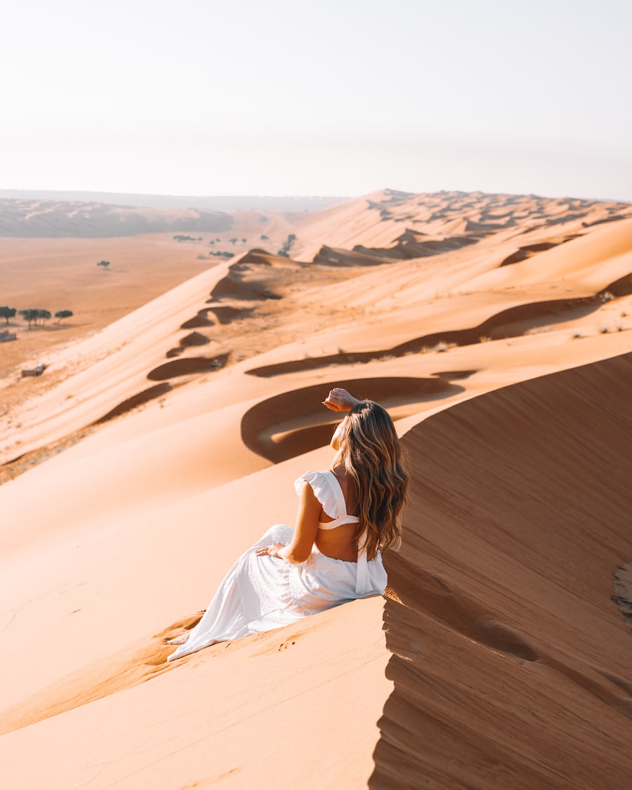 white dress sand dunes Michelle Halpern in white dress sitting on the sand dunes in Oman