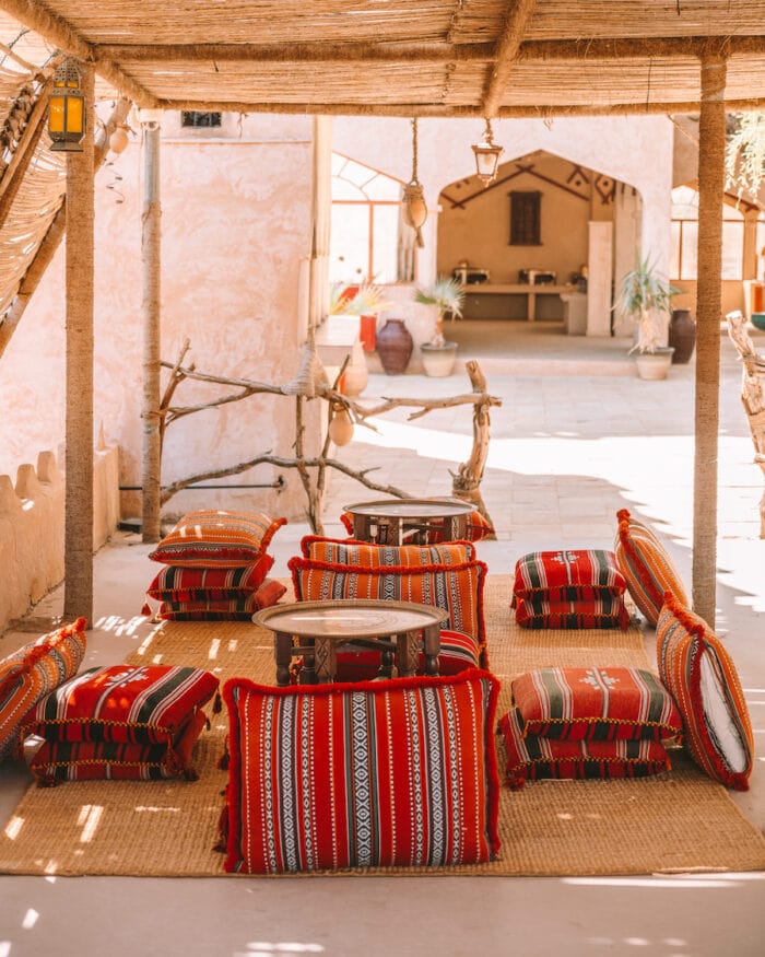 Red cushion seating around tea table at 1000 Nights Desert Camp