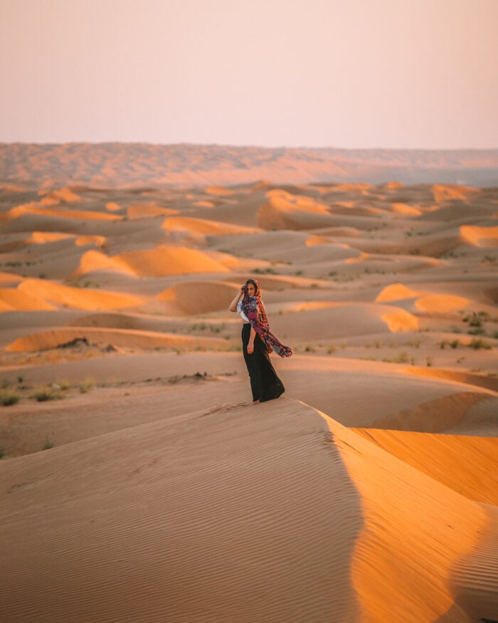 Michelle Halpern standing on the sand dunes in Wahiba Sands at sunset