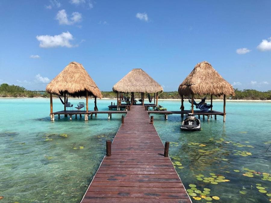 Dock bungalows at Casa Shiva set against bright turquoise lagoon water