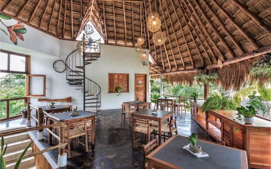 Dining area with tall thatched ceiling at Hotel Aires