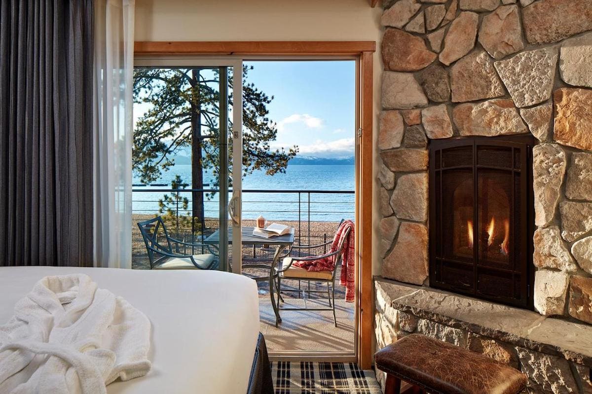 Room view with bed and fireplace in view looking out onto the lake ta the Landing Resort 