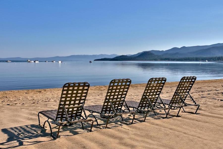 Black beach chairs lined up on the sand