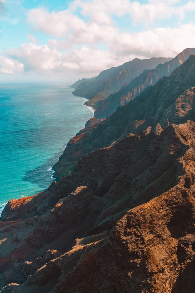 Aerial view down the Na Pali coast from inside a Kauai doors off helicopter tour