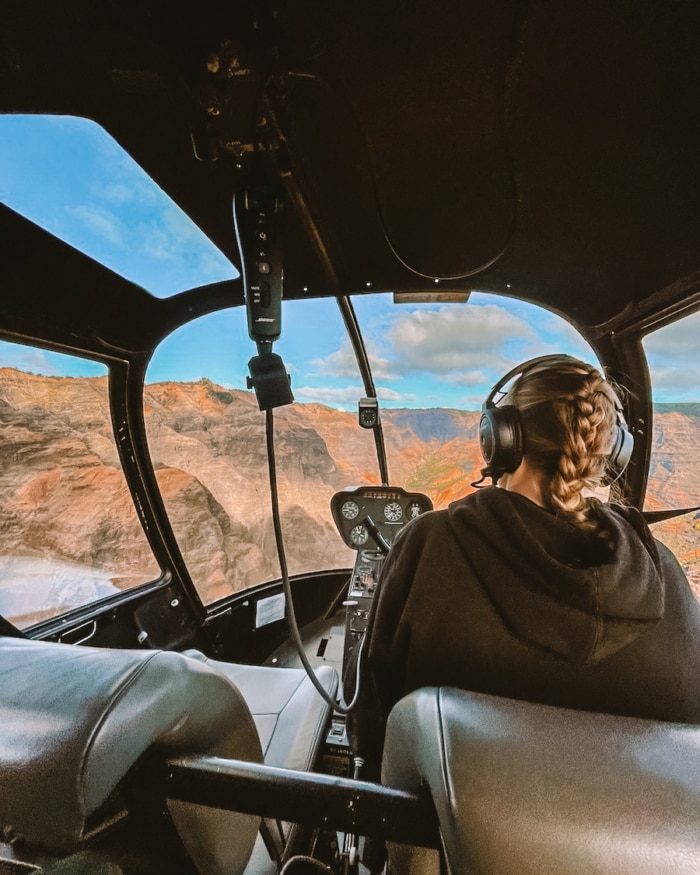 pilot in the cockpit of a doors off helicopter tour in Kauai