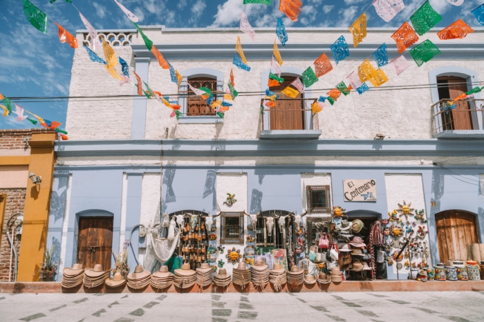 Colorful streets of Todos Santos with hats and goods lined up outside