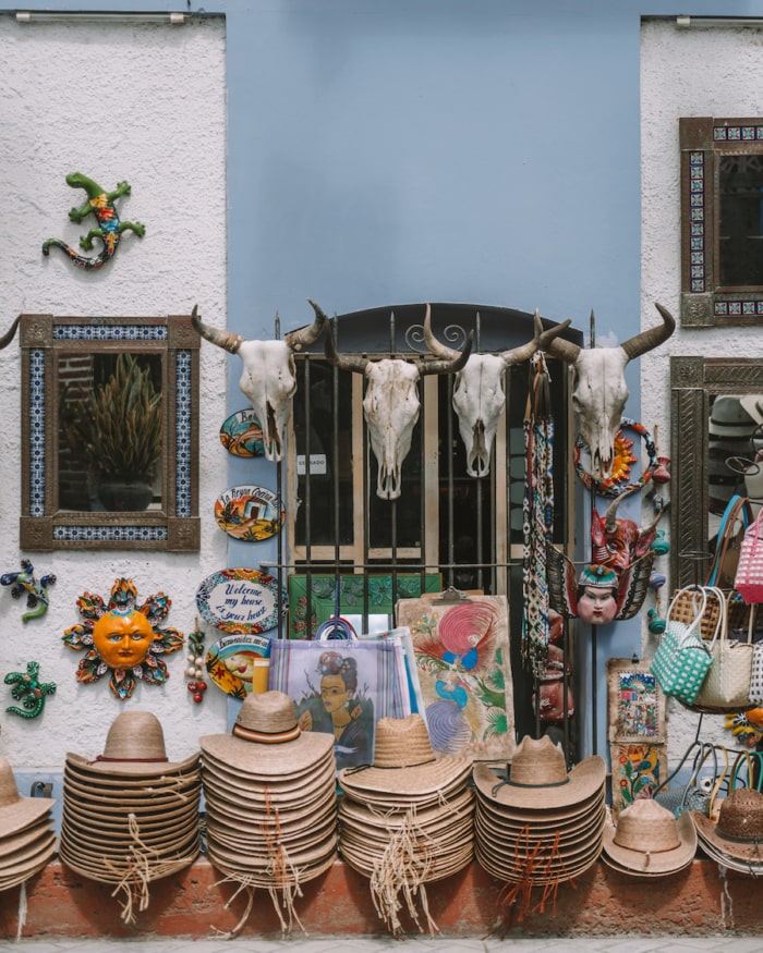 Colorful streets of Todos Santos with hats, cow skulls, and goods lined up outside