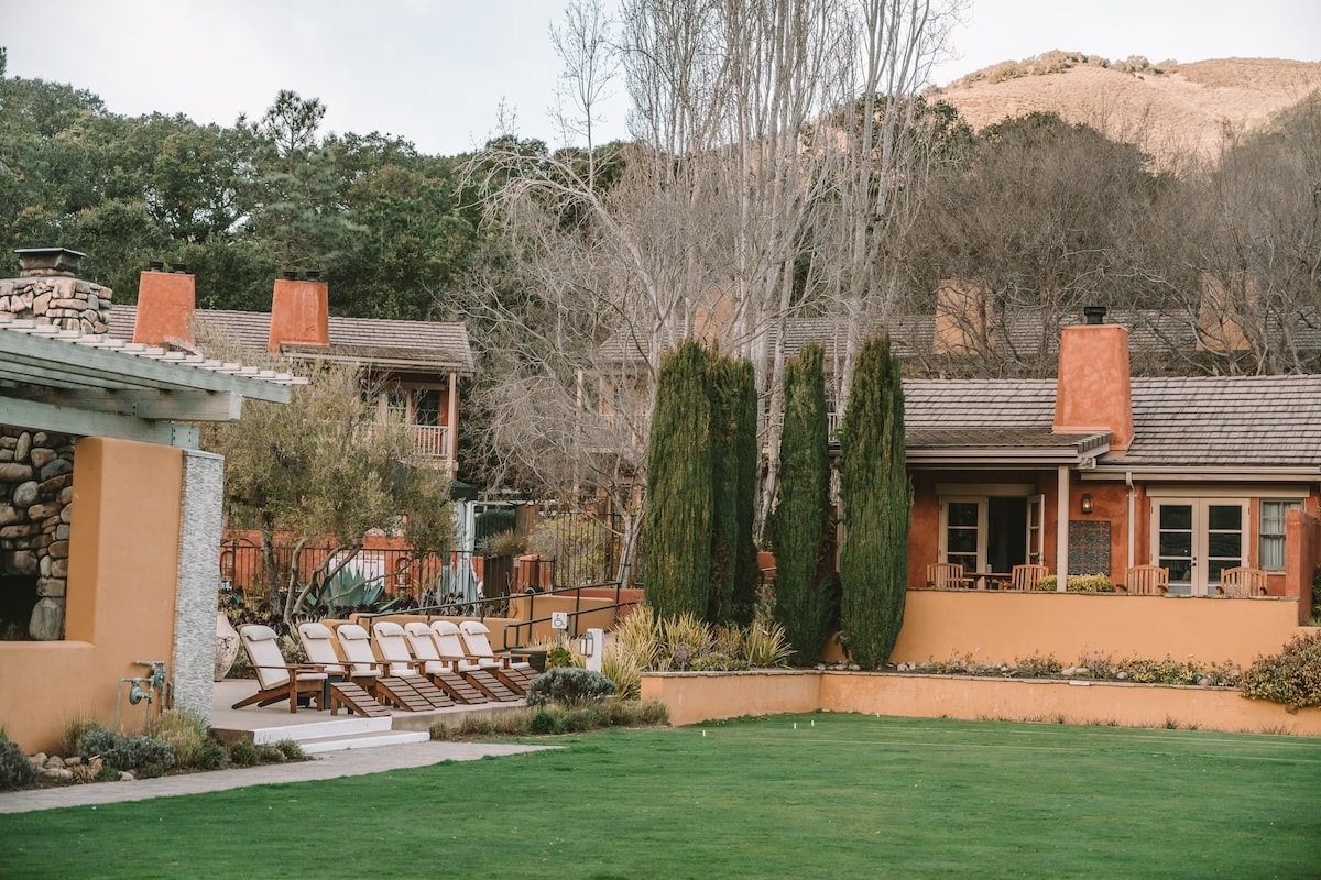 Grassy lawn with guest rooms behind it at Bernardus Lodge & Spa
