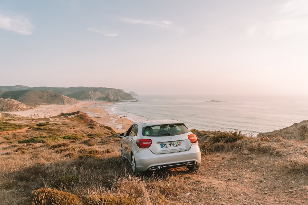 Rental car on top of hill looking down over Praia do Amado