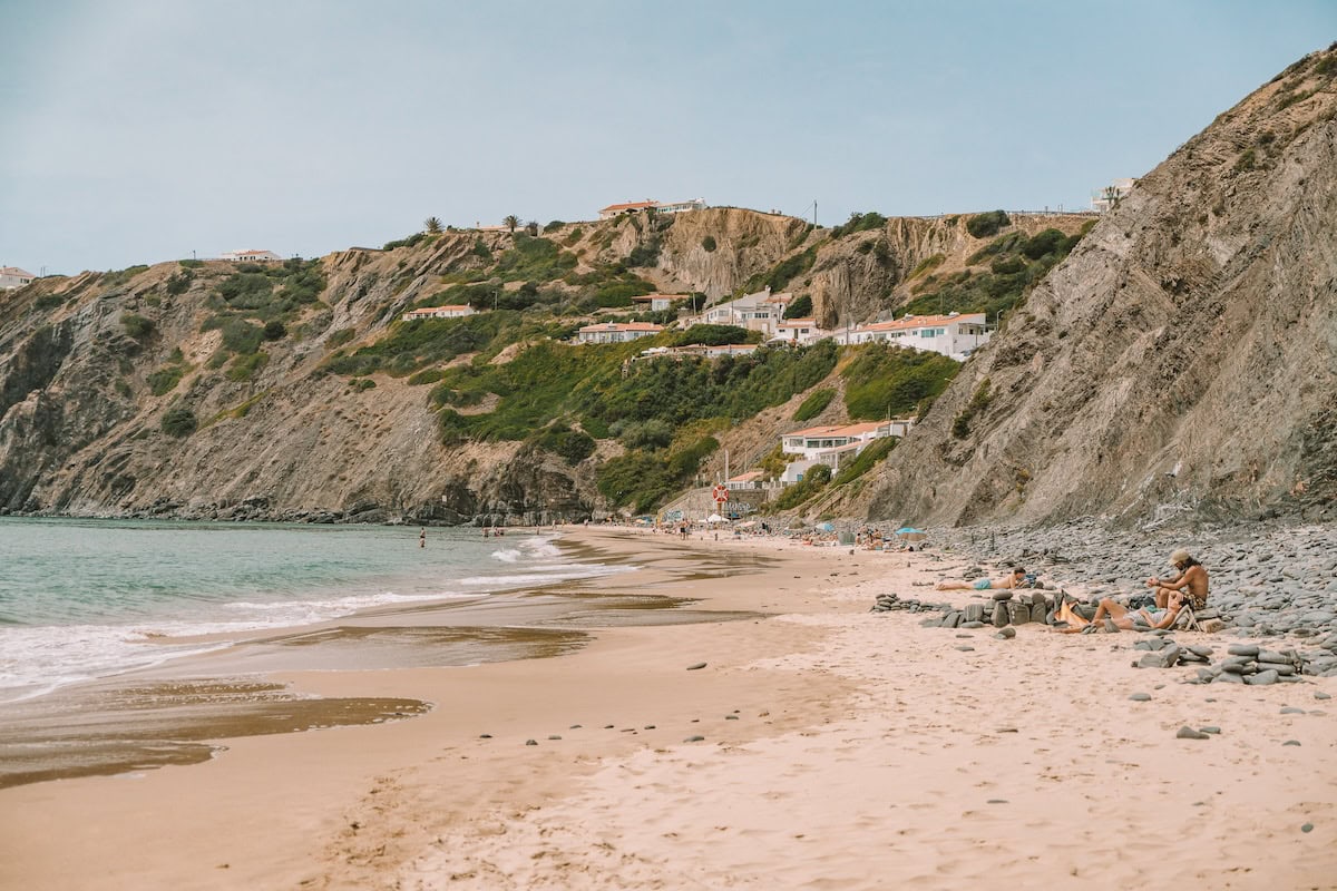 View of Arrifana Beach from the sand looking out onto cliffs and town