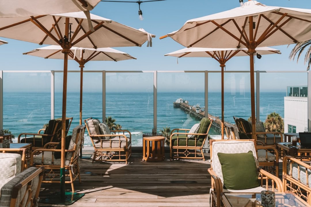 Seating at the Mission Pacific Rooftop Bar with ocean views in the background