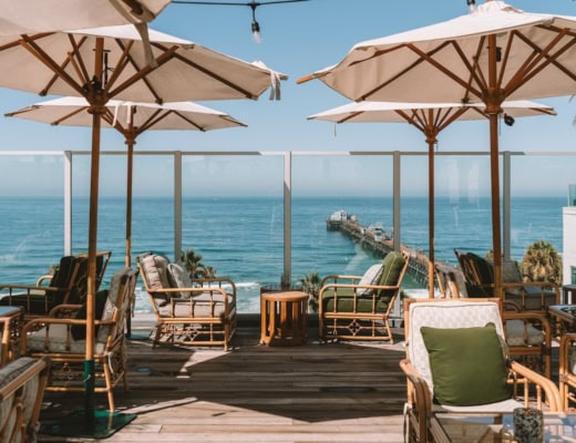 Seating at the Mission Pacific Rooftop Bar with ocean views in the background