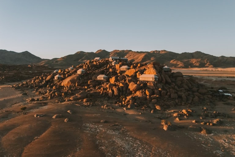 Drone shot of luxury safari tents amongst boulders at Zannier Sonop Namibia