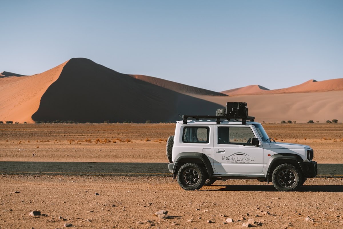amibia Car Rental Namibia Car Rental vehicle parked on the side of the paved road in Sossusvlei Namibia