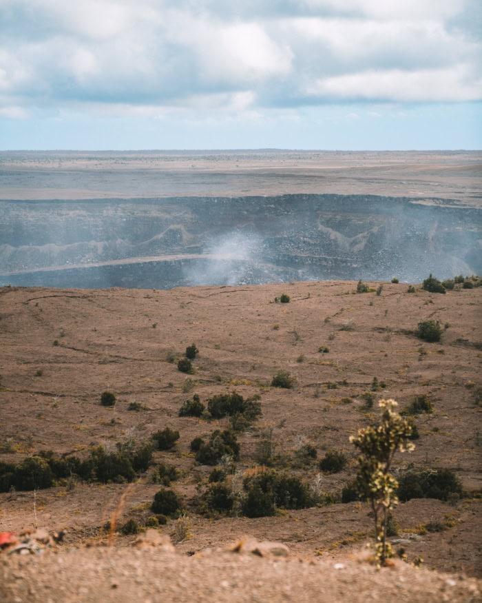 volcanic crater View of a vast volcanic crater emitting steam gas under a cloudy sky on the Big Island of Hawaii.