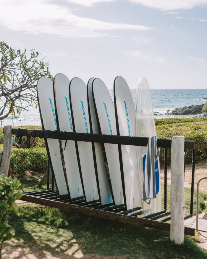 surf boards Rack of white surf boards with an ocean view in the background.
