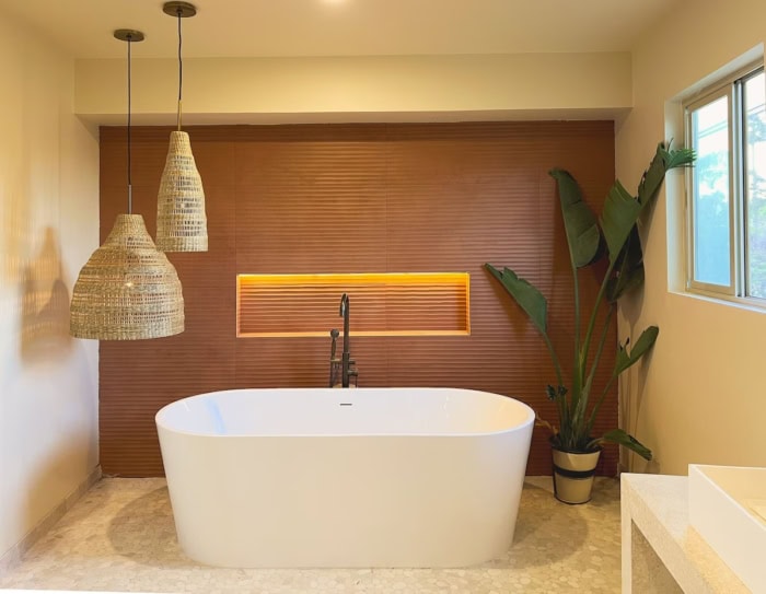 White bathtub White bathtub sitting in a clean minimalist room with hanging lights and plants in the corner.