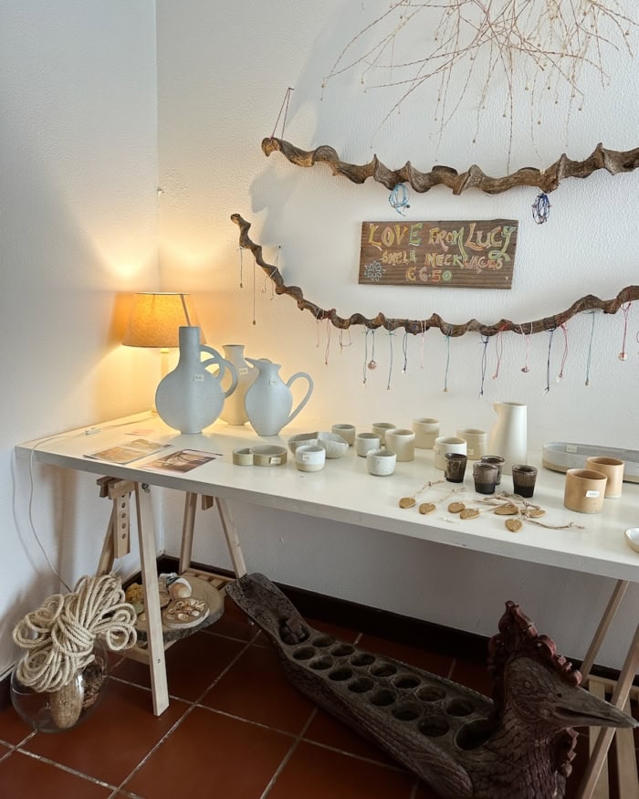 artisan goods White table with ceramics and other artisan goods on display.