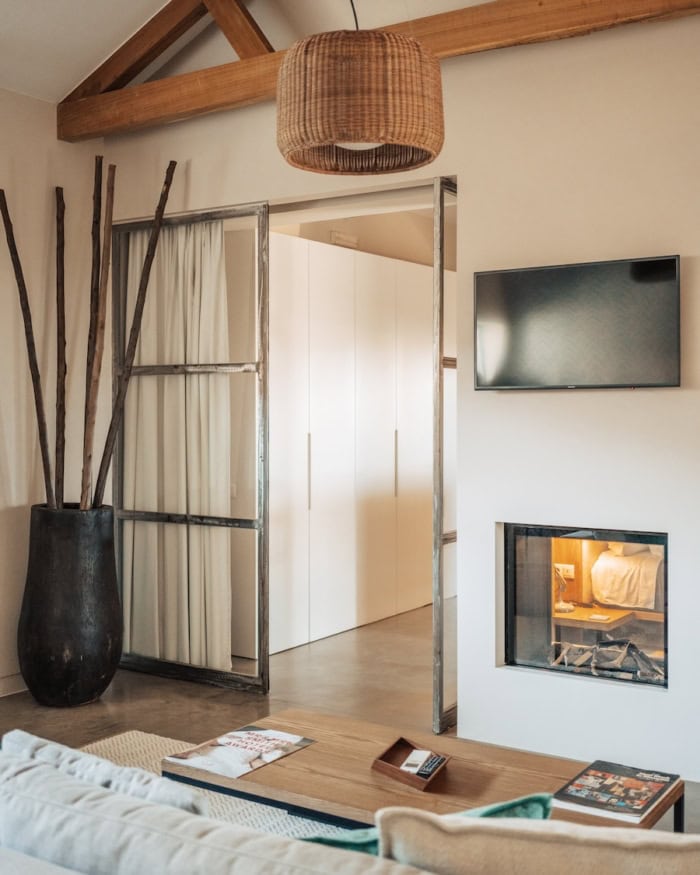 interior at Fazenda Nova Country House White walled interior at Fazenda Nova Country House featuring a fireplace integrated into the wall, TV, and exposed wooden beams