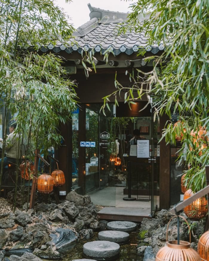 Cheongsudang Bakery Exterior of Cheongsudang Bakery surrounded by lush green plants and a stone walkway leading up to the entrance.